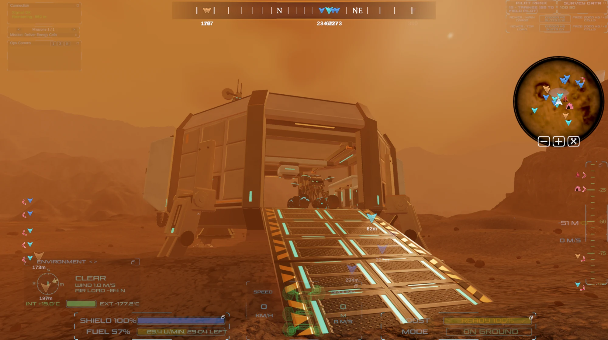 A rover sits inside a modular outpost with an extended ramp and cyan service lights; development HUD is visible.